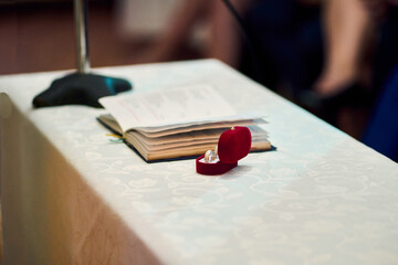 A glimpse of a couple renewing their vows, exchanging rings, a view of rings in a marriage, placing them on their fingers, alongside a priest, at a wedding celebration. Love, ritual, togetherness.
