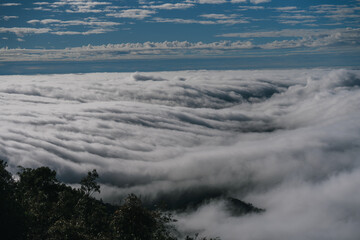A breathtaking view of rolling clouds over a landscape, showcasing a serene sky with scattered clouds, creating a tranquil and captivating atmosphere.