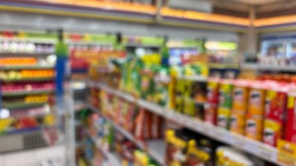 Naklejka premium Defocused image of a supermarket aisle. Center and side perspective. Colored product shelves.