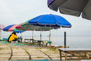 Beach chairs and umbrellas with people looking blurry.