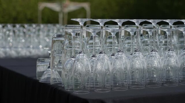 Rows Of Glassware Lined On Long Table, Inverted Crystal Stemware Polished And Arranged In Precise Rows, Soft Outdoor Light Creating