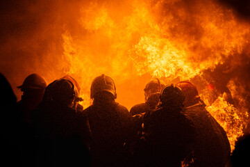 Silhouette of firefighters training for disaster relief officers.Firefighter using water and fire...