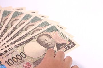 1万円札を指差す子どもの手