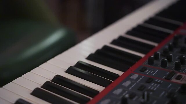Closeup Red Synthesizer Keyboard In Studio, Soft Ambient Lighting, Detail On Keys And Control Knobs, Subtle Motion Suggesting Hands, Warm