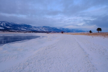 Baikal Lake in winter. Beautiful landscape with mountains reflected in ice of frozen Small Sea