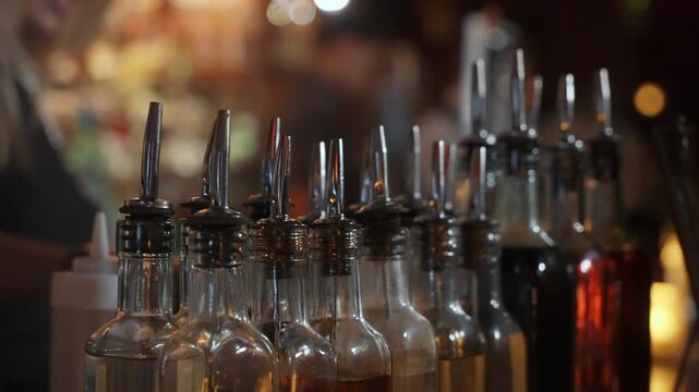 Row Of Pourer Bottles Lined On Bar Shelf Metal Spouts And Amber Liquids Cocktail Station Prepared For Busy Bartender Service During Evening
