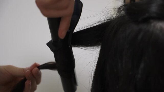 Stylist Curling Long Hair With Curling Iron CloseUp Hands Wrapping Section, Salon Tools Visible, Focused Technique And Finish