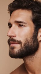 Obraz premium Confident Bearded Man with Glowing Skin in Warm Golden Lighting 