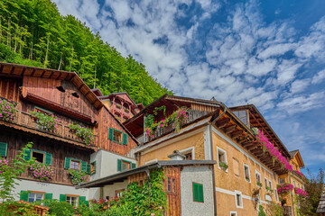 Wooden and rendered alpine houses with bright pastel-colored painted exteriors and lush plant and flower boxes outside windows at the UNESCO Heritage listed village of Hallstatt, Austria, Europe