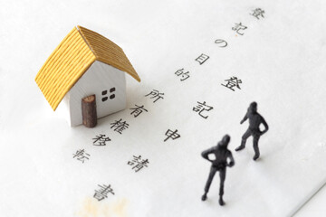 遺産相続のトラブルをミニチュア人形と家と文言で表現した写真