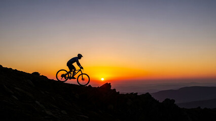 Silhouette of a mountain biker ascending a steep hill at sunset illustrating concepts of challenge adventure and an active lifestyle