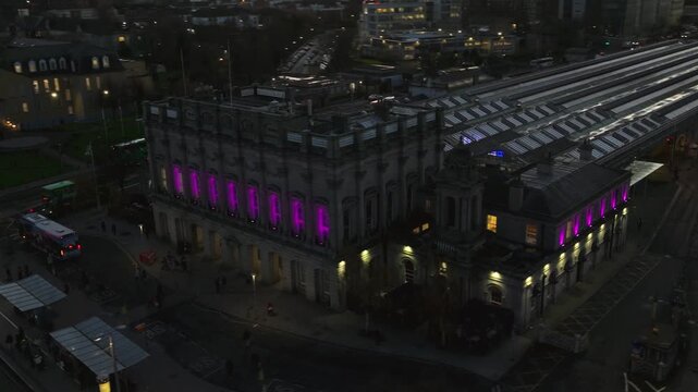 4K cinematic drone footage of Heuston Station in Dublin at sunset, highlighting the historic building, approaching trains, and the Dublin skyline under dramatic sunset hues. Dublin_0010