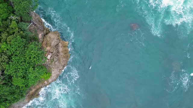 Top Down Drone View of Ocean Waves Crashing on Rocky Coast, Ngliyep Beach Indonesia