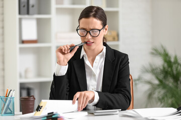 Thoughtful businesswoman working with files at desk in office