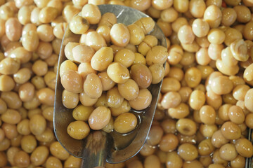 Freshly picked soybeans in a metal scoop at market stall