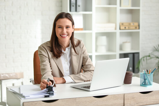 Young businesswoman working at desk in office