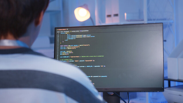 One young male Asian IT freelancer programmer and tech engineer working with computer keyboard, typing software codes for application development and website network system information data in room.
