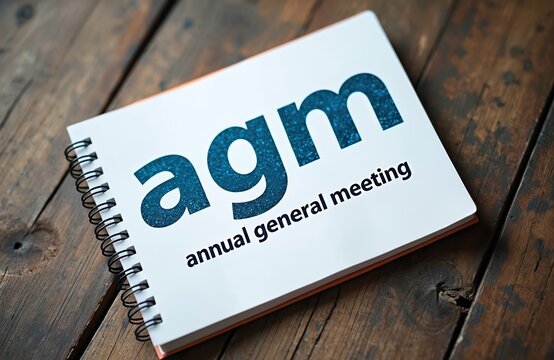Notebook with AGm annual general meeting text. Business concept for corporate meetings and planning. Professional agenda for company discussions.