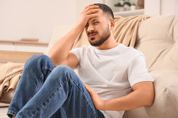 Young man feeling unwell at home