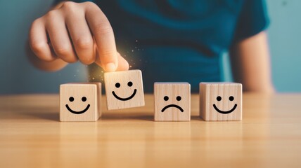 Happiness Cube: A hand delicately selects a smiling cube from a line of wooden blocks depicting varied emotions, symbolizing a positive mindset and emotional balance.