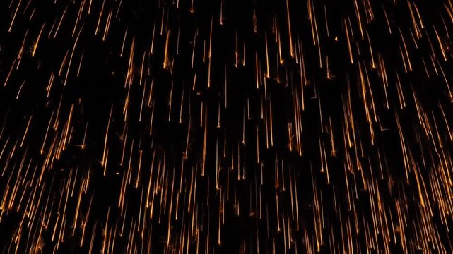 Bright golden fireworks exploding high in the dark night sky, creating dramatic long exposure fiery trails resembling raining meteors.