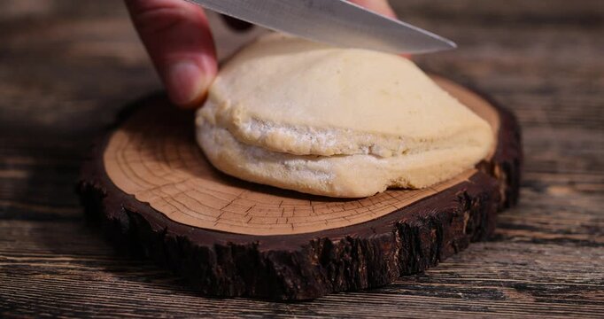 sliced fresh shortbread bun with juicy curd filling on a wooden board on the table, soft pastries stuffed with cottage cheese and sugar lie on the board after being cut