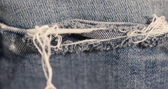 old blue torn jeans from long-term wear, part of blue jeans made of cotton fabric that are frayed and torn from long-term wear and use