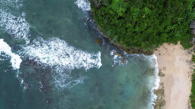 Top Down Drone View of Ocean Waves Crashing on Rocky Coast, Ngliyep Beach Indonesia