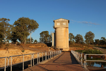 Tall concrete water tower surrounded by trees and rocks at Charters Towers Weir Park in Queensland, Australia