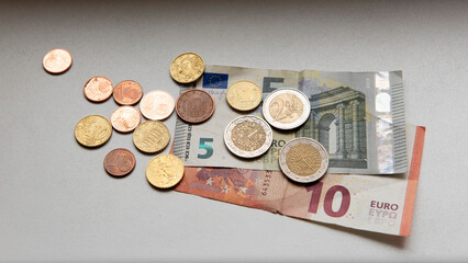 Euro coins with five and ten Euro bills on table
