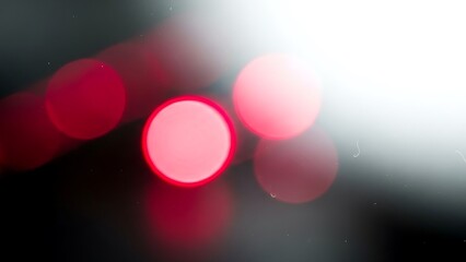 Abstract red bokeh lights on dark background with bright flare