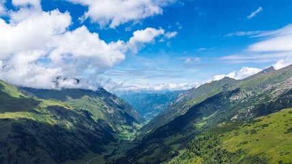 Explore the breathtaking beauty of the Austria Alps, showcasing a lush green valley beneath a bright blue sky. Perfect for travel brochures and nature enthusiasts.