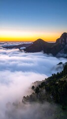 Mountain peaks rising above a sea of clouds at sunset