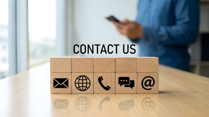 Contact us wooden blocks with communication icons on office table