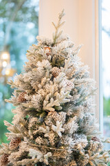 Blue Christmas tree with snowflakes falling on its branches