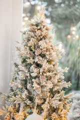 Blue Christmas tree with snowflakes falling on its branches