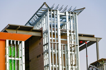 A commercial building under construction with exposed steel framing and vertical supports, illustrating structural assembly, architectural development, and modern construction engineering activity.
