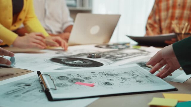 A collaborative team meeting in a creative workspace, focusing on engineering diagrams and project planning materials, fostering innovation and teamwork. SACTR