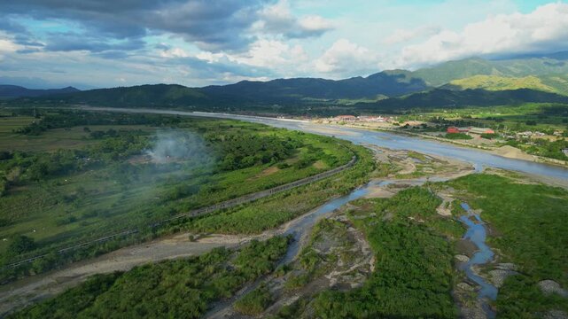 A pull-out aerial of the Chico River reveals scattered water puddles and a vast cast of cloud shadow Bontoc, Nueva Vizcaya, Philippines