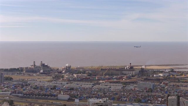 Aerial view of an airplane preparing to land at Aeroparque Jorge Newbery with Villa 31 and Buenos Aires city in the background.