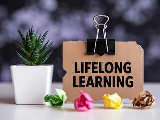 Lifelong learning concept with a plant and crumpled paper on a desk