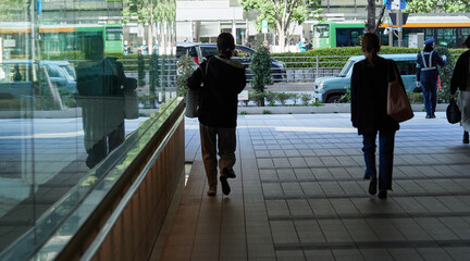 朝の通勤時間の東京都内のオフィス街で歩くサラリーマンたちの姿