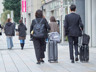 東京都内のオフィス街で歩くサラリーマンと女性ビジネスウーマンの姿