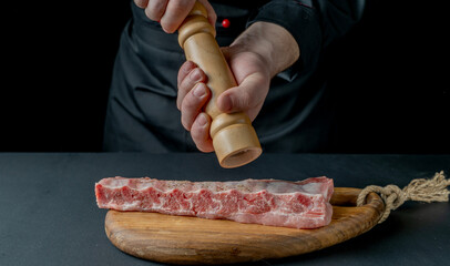 Fried pork ribs with spices on a black background