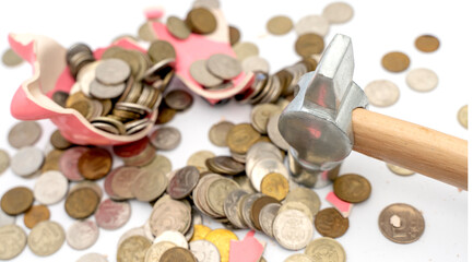 Broken piggy bank on the table with coins