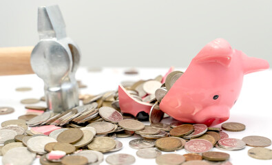 Broken piggy bank on the table with coins