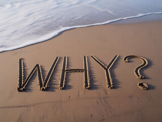 The word "why?" written in the sand on a beach near an approaching wave