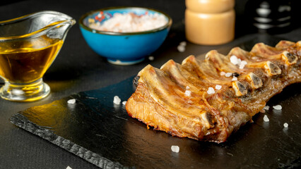Fried pork ribs with spices on a black background