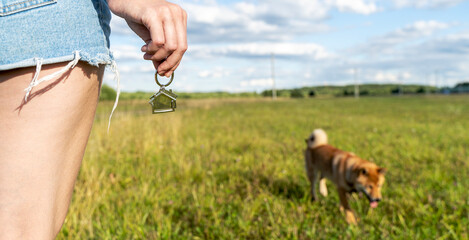 Woman in a field with keys to a new house