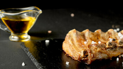 Fried pork ribs with spices on a black background